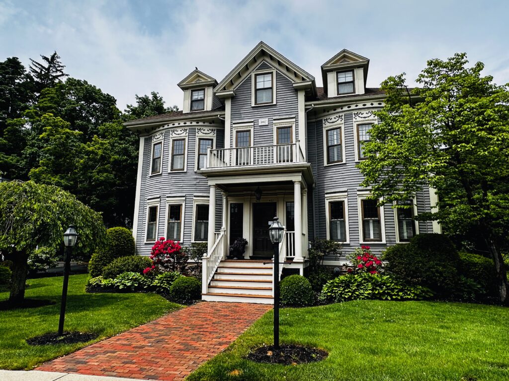 Classic Wellesley Massachusetts home with landscaped front lawn, brick walkway, and traditional New England architecture.